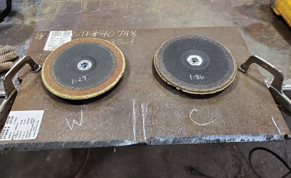 Two abrasive discs on a metal test sheet