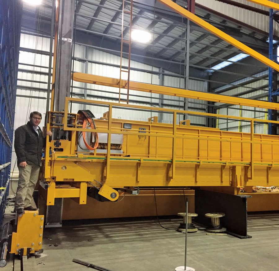Plate Product Manager Sam Stein inspecting stacker crane.