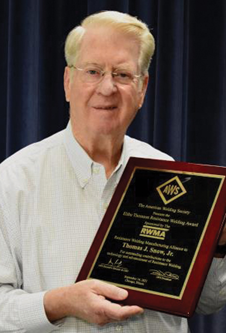 image of Tom Snow holding an award plaque