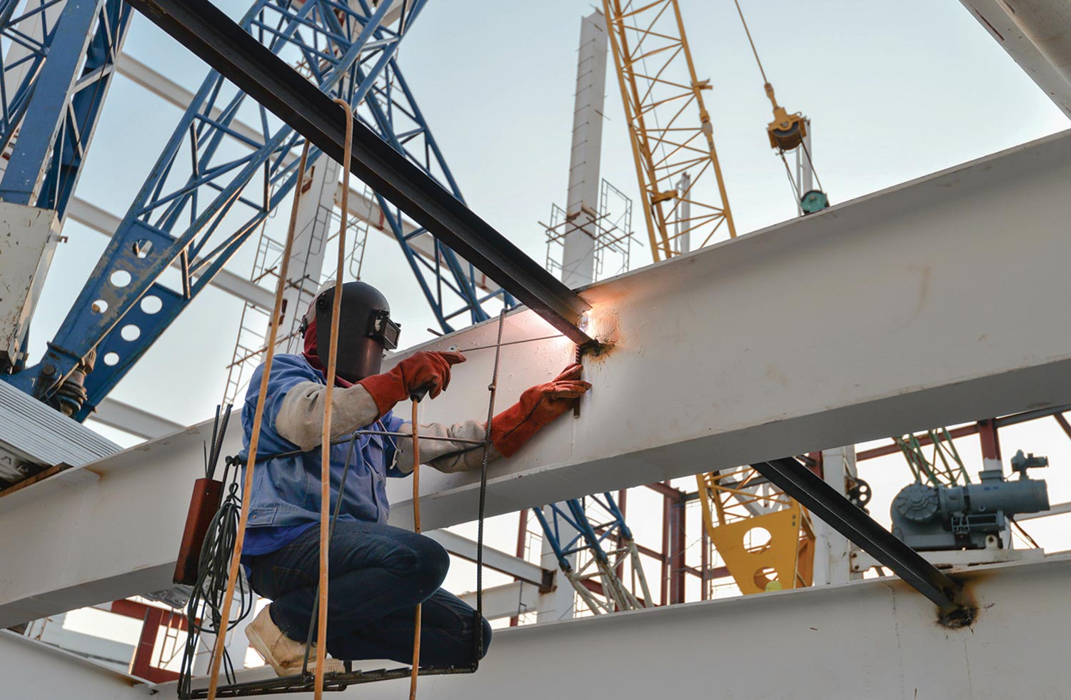 a steel welder working on a large structure