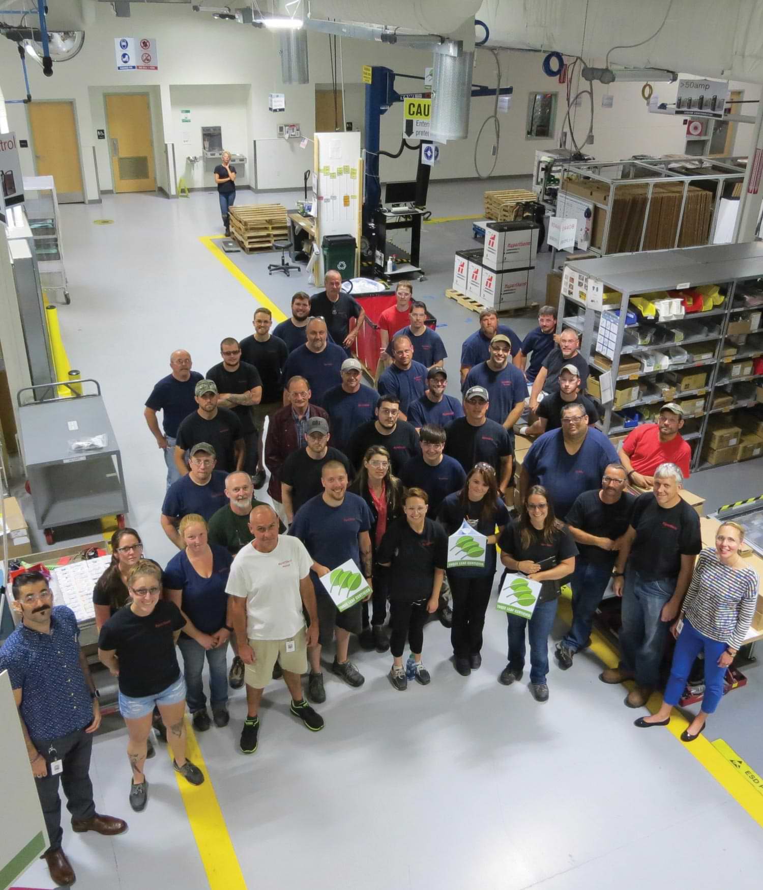 Hypertherm employees stand in together for a group photo inside a factory